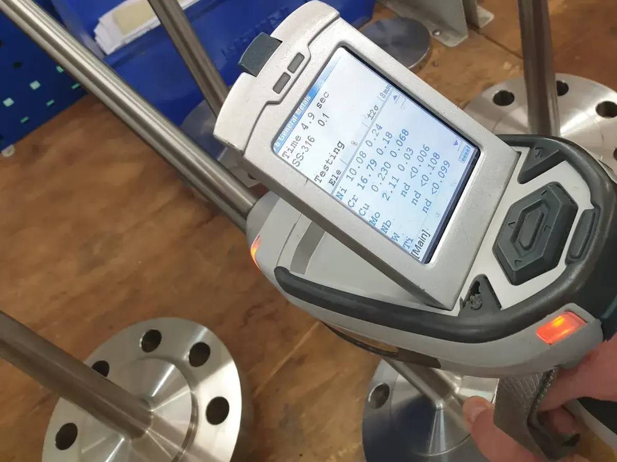 Handheld XRF analyser showing an SS-316 result during positive material identification